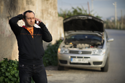 man with phone and broken car